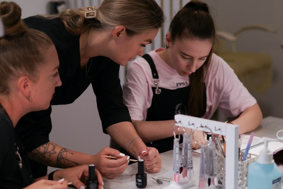 Instructora guiando a sus alumnas durante una clase práctica de uñas